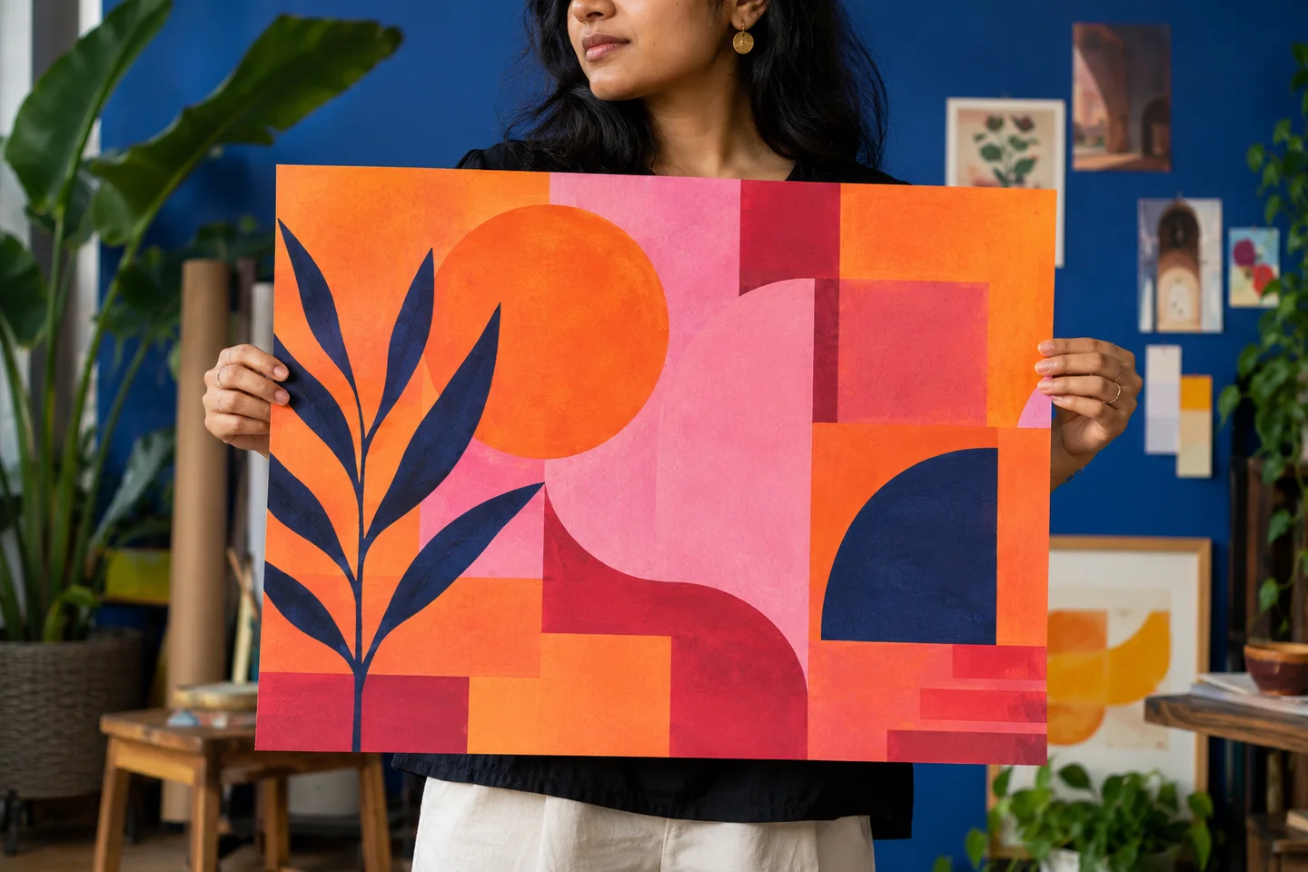 An Indian designer holding colourful geometric paper artwork